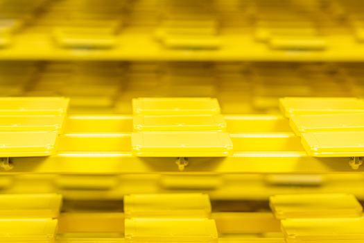 Gelb lackierte Metallbauteile auf einem Gestell